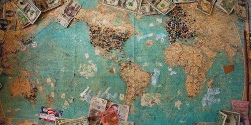 A world map surrounded by money