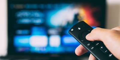 Man pointing a remote control at a TV