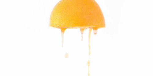 Juice drips from an orange half