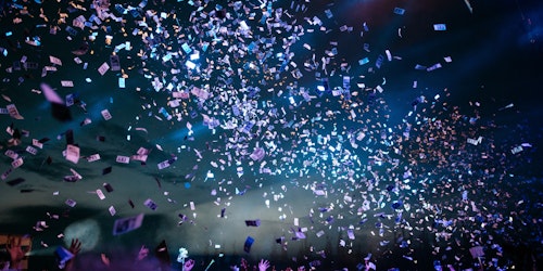 Fans at a festival, under a shower of paper money