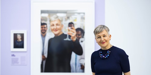 A woman with her portrait at the Saatchi gallery 