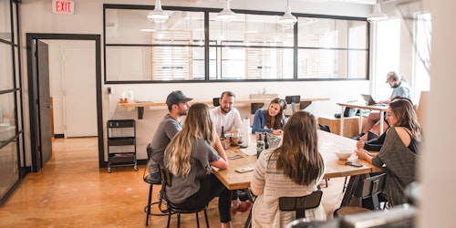 People sat around a table talking in a meeting