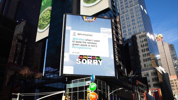 A Times Square billboard with a Skitttles ad apologizing to angry fans 