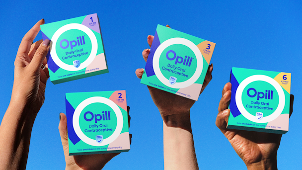 Packets of Opill held aloft by hands