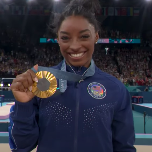 Simone Biles holds up a gold medal at the 2024 Paris Olympics