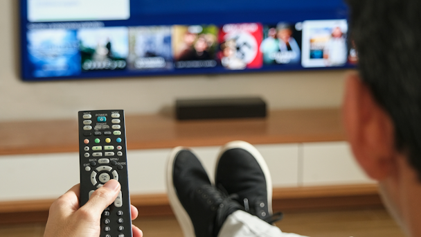 guy with remote control sitting in front of TV