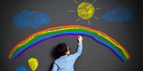 A child draws on a wall in chalk