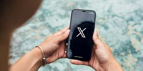 Person opening X app on their mobile phone